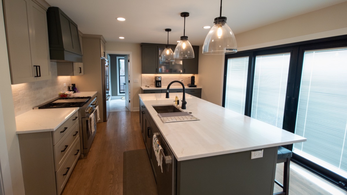 Chef's kitchen with statement pendant lighting over center island by QKC, Wisconsin luxury contractor
